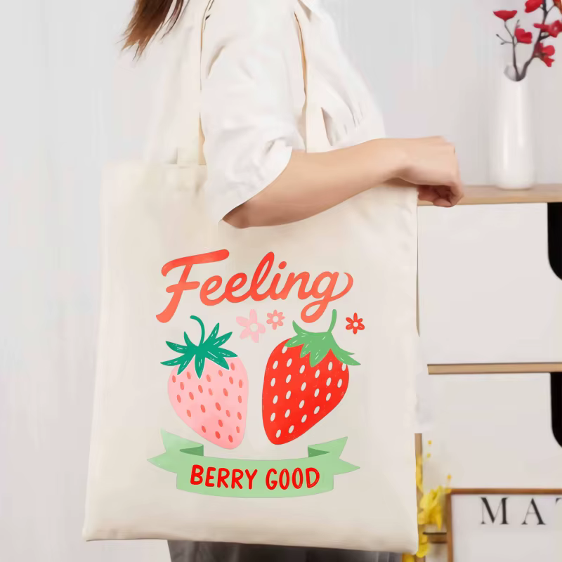 Sac fourre-tout en coton imprimé fraise de couleur crème avec un design de texte "feel so good", ada