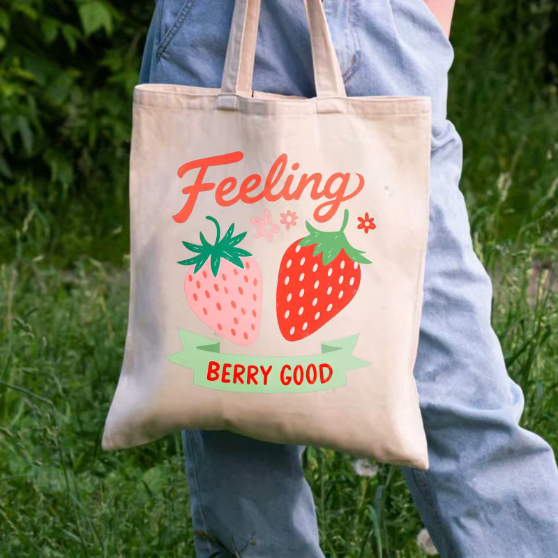 Sac fourre-tout en coton imprimé fraise de couleur crème avec un design de texte "feel so good"
