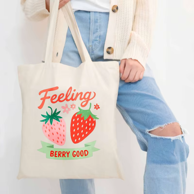 Sac fourre-tout en coton imprimé fraise de couleur crème avec un design de texte "feel so good"