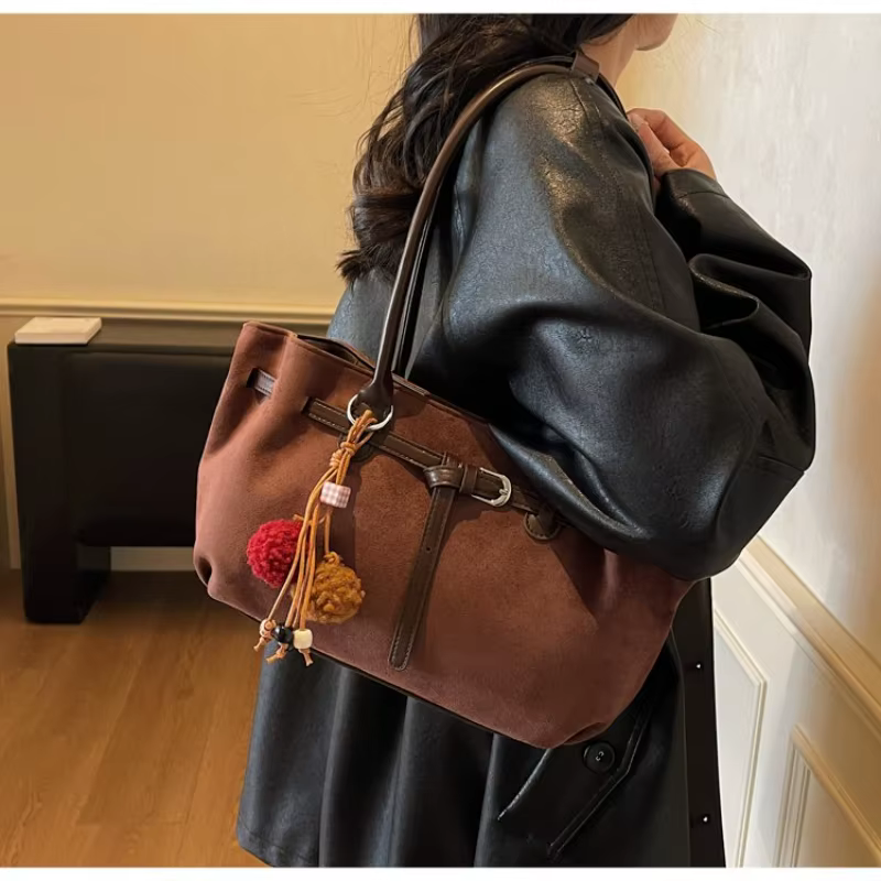 Sac à bandoulière en daim marron pour femme avec pompon décoratif
